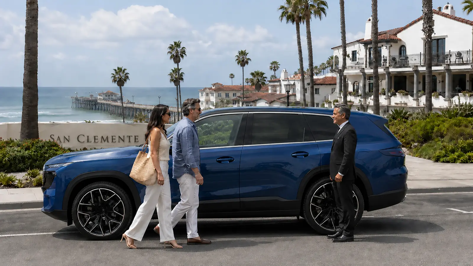 Private driver greeting a couple beside a blue SUV overlooking the San Clemente pier.