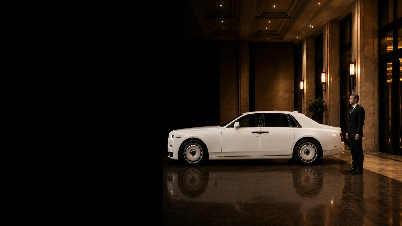Private driver waiting beside a white luxury sedan at a grand event entrance.